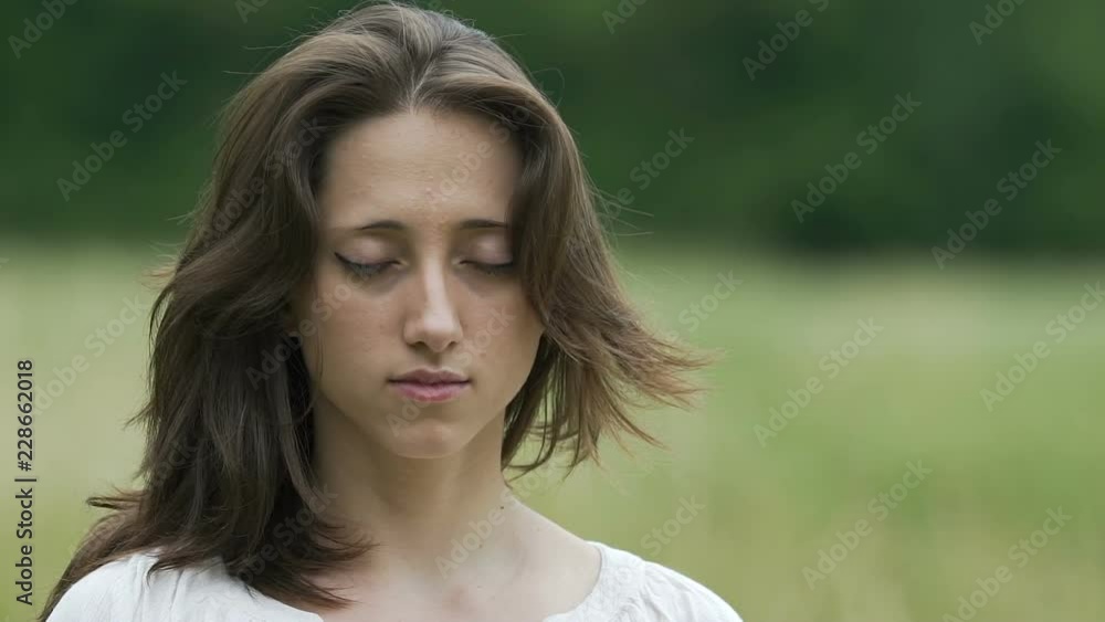 Brunette woman with closed eyes raises head and moves her hair deep relaxation Brunette woman with closed eyes raises head and moves her hair deep relaxation
