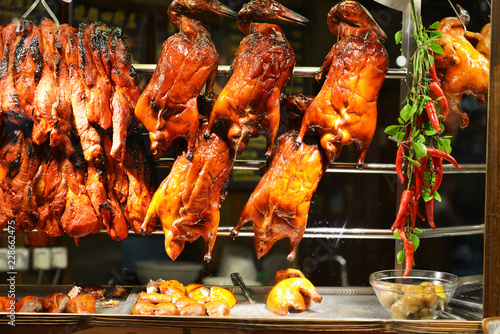 Photography Hanged roasted ducks in a showcase on street food market in Singapore