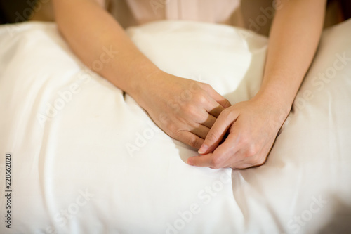 Young girl lay hands on a pillow  with hands clasped  hand for sign and symbol