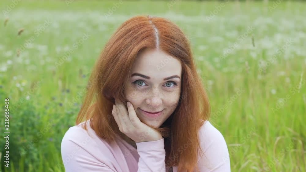 Shy red haired female raises eyes to flirt with camera, adorable woman look slow Shy red haired female raises eyes to flirt with camera, adorable woman look slow