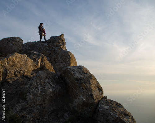 UOMO CON BAMBINA IN CIMA ALLE ROCCE