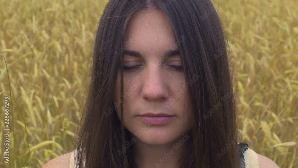 Relaxed woman with closed eyes stands in wheat field, meditation outdoor memory Relaxed woman with closed eyes stands in wheat field, meditation outdoor memory