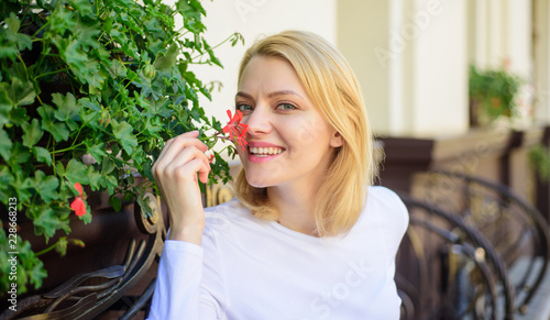 Beautiful terrace attract clients. Plants as natural decoration. Girl sit cafe sniff flowers aroma. Woman sit cafe terrace enjoy flower fragrance. Woman wait date. Enjoy every moment of your life