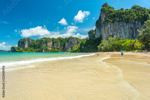 Railay Beach West. Cliffs covered with jungles and clear water during a beautiful sunny day in July (low season). Krabi, Thailand photo