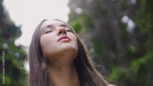 Lady with closed eyes listens to birds and nature around, surrounding sounds