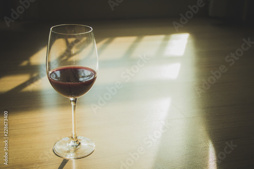 Red wine in wineglass against wooden background.