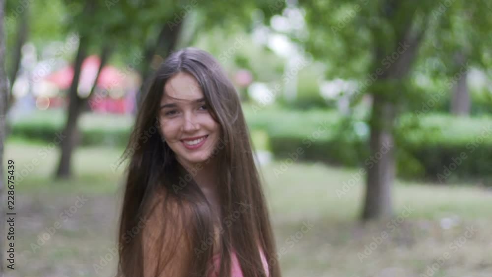Young pretty lady turns around flips hair smiling beautiful woman joyful outdoor Young pretty lady turns around flips hair smiling beautiful woman joyful outdoor