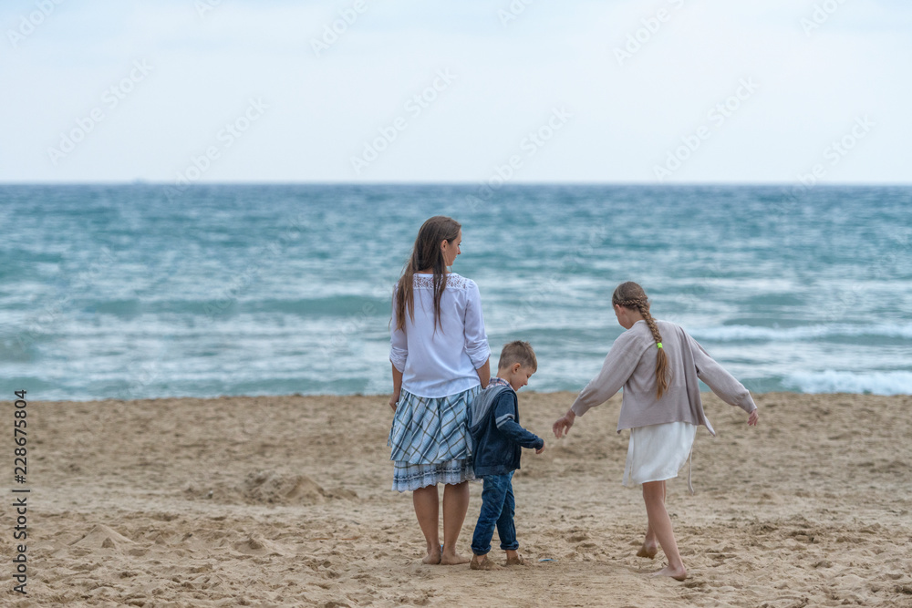 mother and her daughter and son having fun on the beach mother and her daughter and son having fun on the beach