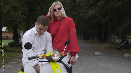 Handsome guy on a scooter is talking to a girl photo