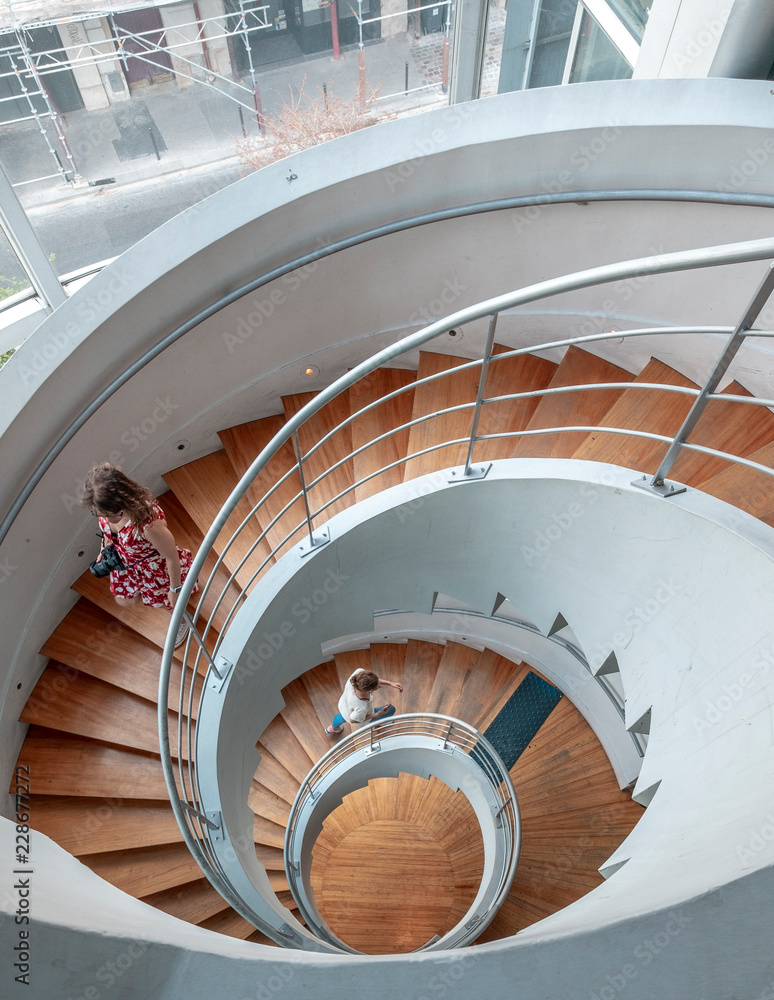 Fototapeta premium Two people upstairs in spiral staircases in Paris france