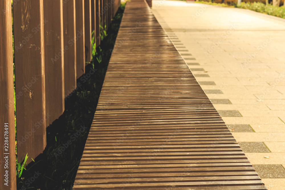 Wooden bench in perspective from bars on the street, art decor Wooden bench in perspective from bars on the street, art decor