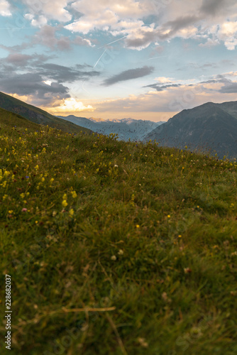 Sonnenuntergang in den Alpen auf einer Wiese mit Blick auf Berge