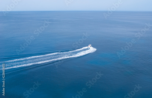 White motor boat with long trail behind © Simona