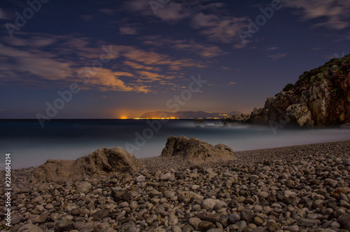 panorama notturno con citta sullo sfondo e ghiaia in primo piano. Riserva naturale orientata dello Zingaro