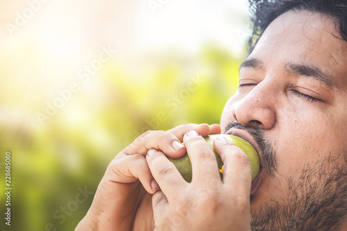 Indian man eating mango.