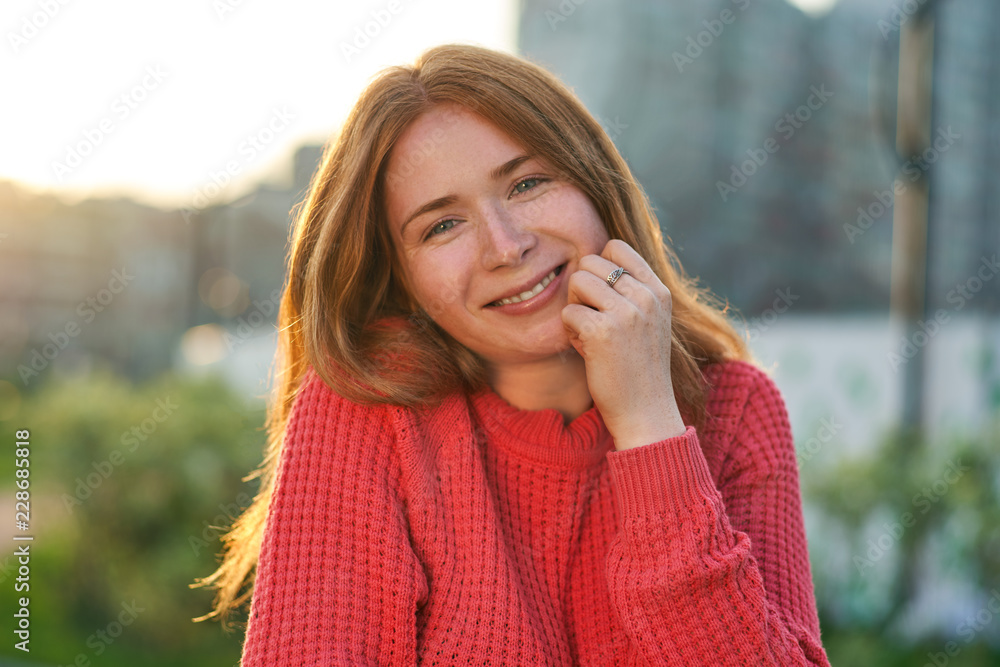 Portrait of a cute red-haired girl. Happy woman looking at camera with shining eyes and wide smile