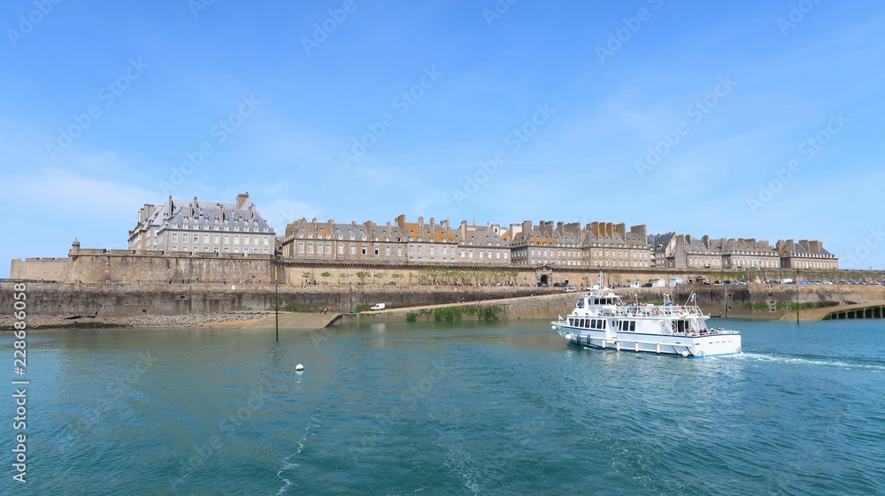 Vue sur les remparts de Saint-Malo, avec un bateau s’apprêtant à accoster (France)