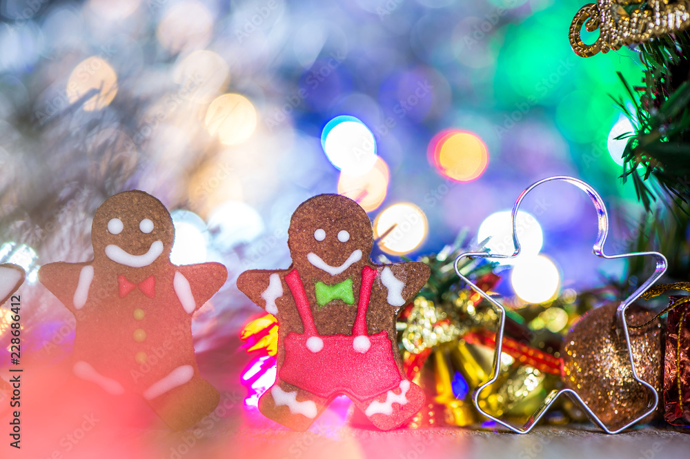Fototapeta premium Cute gingerbread man with christmas tree and blurry sparkle background, close up, bokeh, text space(copy space)