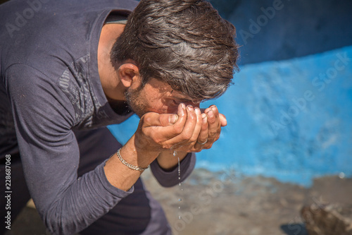 Poor Indian man Drinking Water