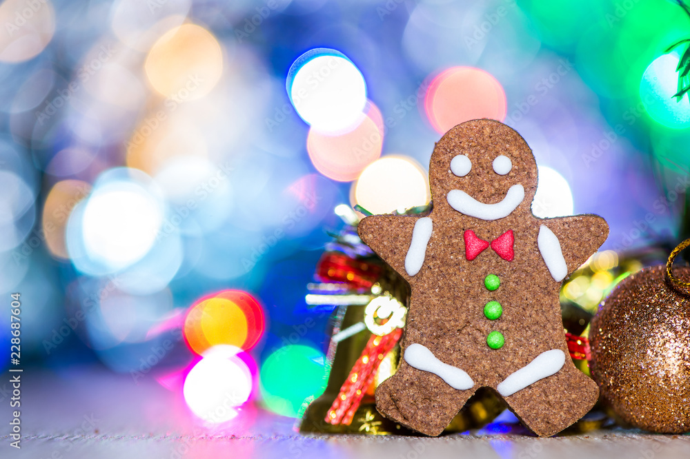 Obraz premium Cute gingerbread man with christmas tree and blurry sparkle background, close up, bokeh, text space(copy space)