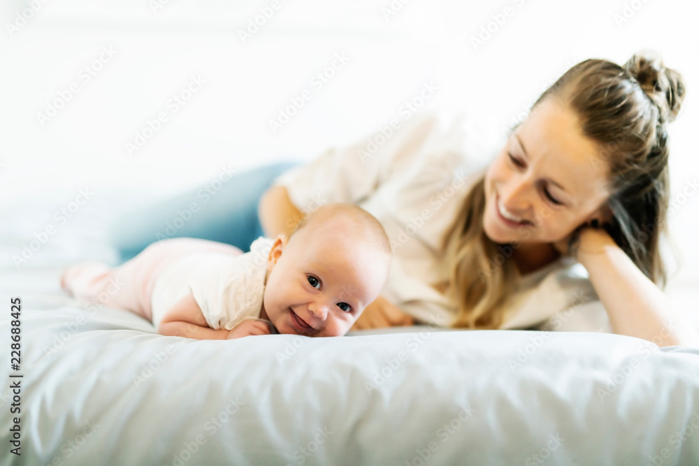 Portrait of a beautiful mother with her 2 month old baby in the bedroom Portrait of a beautiful mother with her 2 month old baby in the bedroom