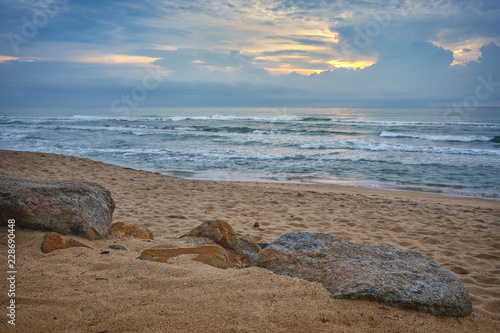 rock on the beach with seascape sunset skyline