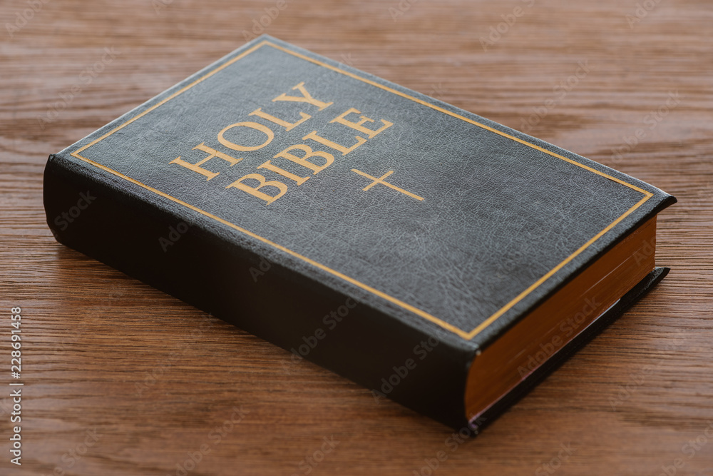 close-up shot of holy bible lying on wooden surface close-up shot of holy bible lying on wooden surface