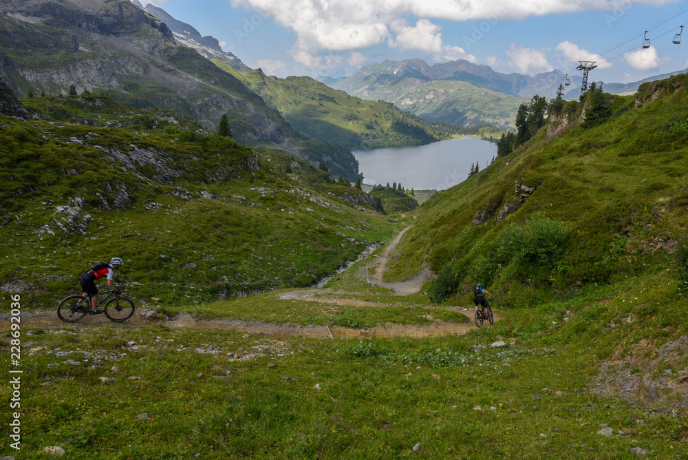 People on their mountain bikes going down the path from Jochpass
