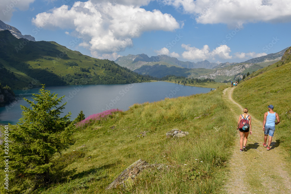 Naklejka premium People hiking at lake Engstlensee on the Swiss alps