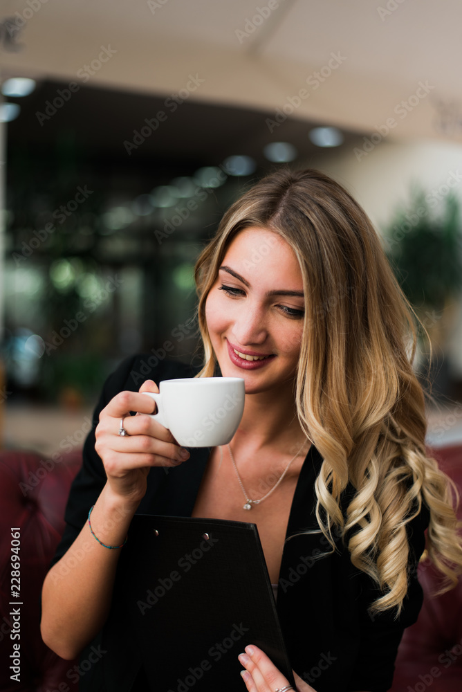 Beautiful blonde businesswoman working and drinking coffee in the office. Beautiful blonde businesswoman working and drinking coffee in the office.