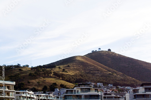Landscape of Signal Hill in Cape Town on a cloudy day, with upmarket apartments in the foreground © Luke