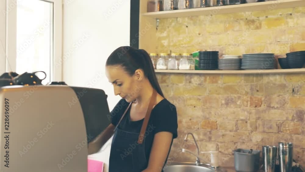 Waitress serving customer, giving two cups of coffee. Customer showing result of the transaction. Smartphone payment. Waitress serving customer, giving two cups of coffee. Customer showing result of the transaction. Smartphone payment.