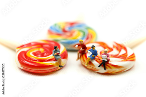 Miniature people : Businessman and friend sitting with colorful candy lollipop,relax time concept.