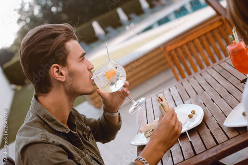 Man drinking cocktail and lunching
