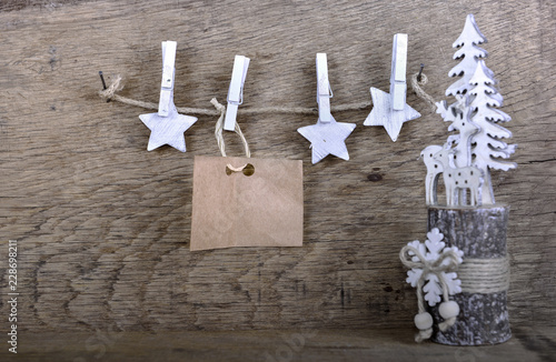 paper sign for message and  white stars hung at a string on wooden background