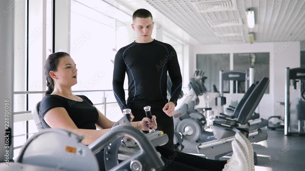 Personal fitness coach control beginner sports woman in gym Personal fitness coach control beginner sports woman in gym