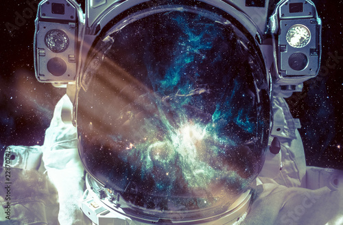 Dark nebula and stars in space, reflection on the spacesuit helmet. Adventure of spaceman. Astronaut in outer space. Elements of this image furnished by NASA.