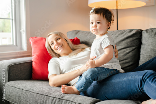 Portrait of little girl with mother on the living room