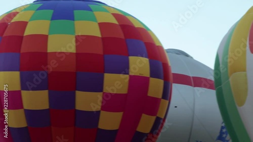 panning shot across a field of hot air balloons setting up to take off at a festival