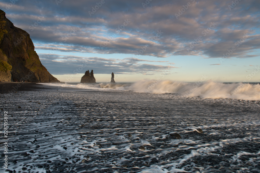 Famous Reynisdrangar rock formations at black Reynisfjara Beach. Coast of the Atlantic ocean near Vik, southern Iceland.