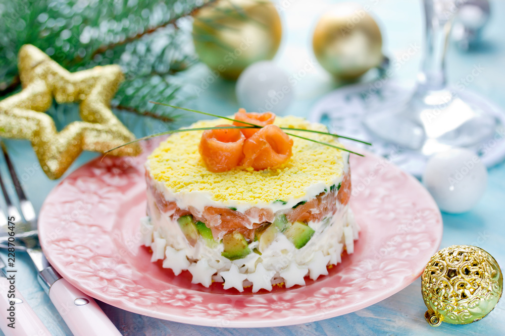 Christmas layered salad with salmon, avocado, rice and cream cheese salad on holiday table Christmas layered salad with salmon, avocado, rice and cream cheese salad on holiday table