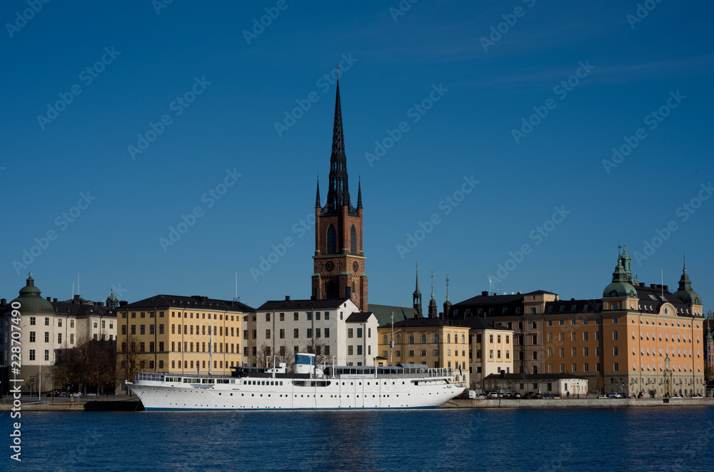 Stockholm water front with landmarks, boats an autumn day with blu sky and sea, orange and red leafs.