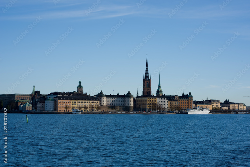 Stockholm water front with landmarks, boats an autumn day with blu sky and sea, orange and red leafs.