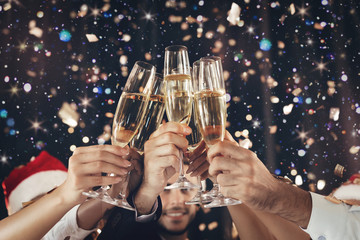 Clinking glasses of champagne in hands at New Year party
