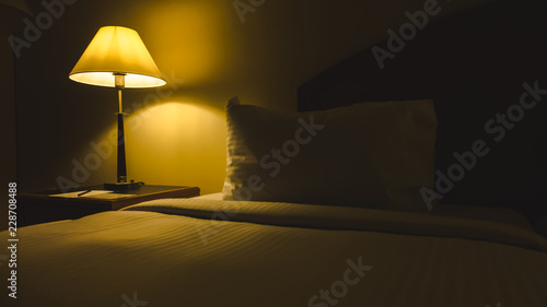 Closeup shot of comfortable hotel bed with lamp table beside bed