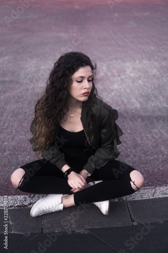 Young woman sitting on ground photo