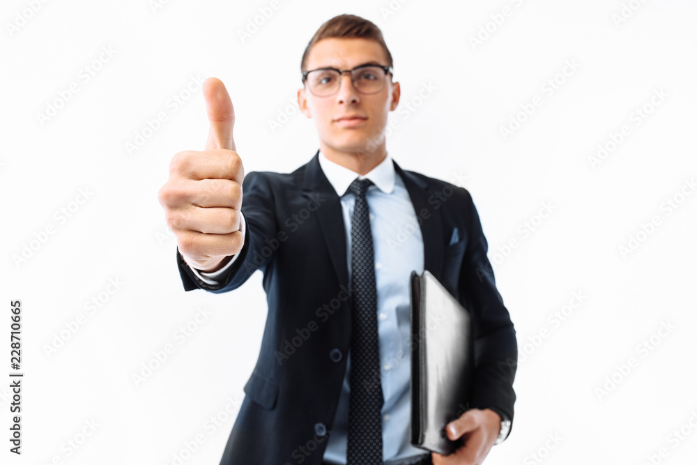 Man businessman, in black suit and glasses, with folder in hand, smiling shows class gesture, isolated on white background Man businessman, in black suit and glasses, with folder in hand, smiling shows class gesture, isolated on white background