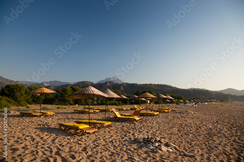 Fototapeta Naklejka Na Ścianę i Meble -  CIRALI, TURKEY Sunloungers on beach at sunrise.