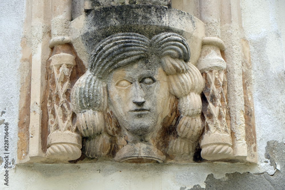 Architectural detail with a mascaron of a woman on the facade of an old building in Varazdin, Croatia