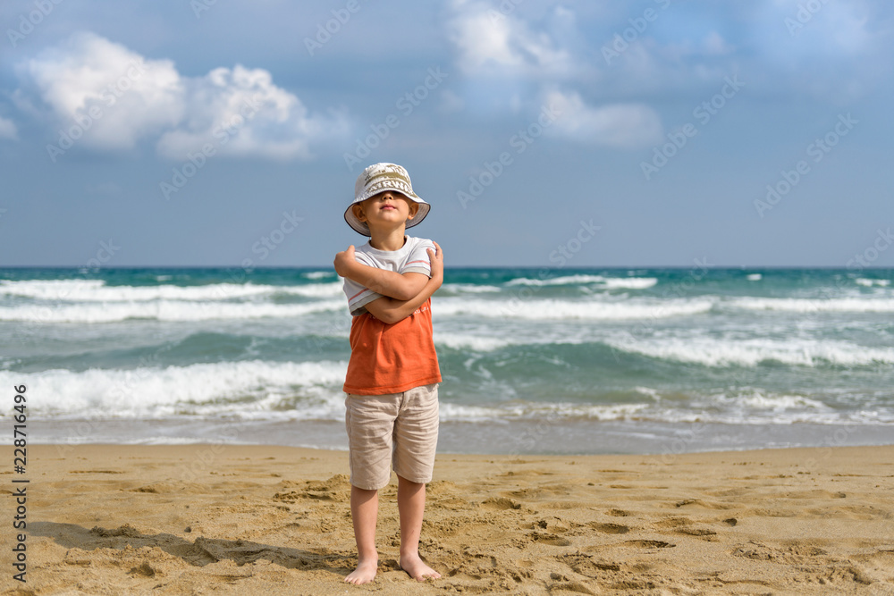 little boy on the beach playing with sand